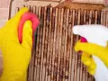 Gants jaunes, éponge et spray pour apprendre comment nettoyer le dessus d'une cuisinière en fonte.