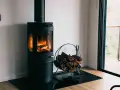 Poêle à bois moderne avec flammes vives et bûches. Une question se pose : peut-on installer un poêle à granule soi même ?