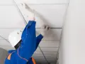 Pose d'un faux plafond dans un garage, améliorant l'isolation et l'esthétique.