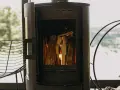 Poêle à bois allumé, avec une prise d'air poele à bois obligatoire pour une combustion optimale. Le feu crépite joyeusement.