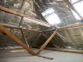 Isolation des combles : le prix au m2 dépend de la technique. Vue d'un grenier en cours d'isolation avec matériaux réfléchissants.