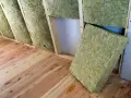 Isolation d'un grenier avec de la laine de verre sans pare vapeur, posée entre les chevrons sur un plancher en bois.