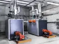 Deux chaudières industrielles modernes, prêtes à fournir de l'eau chaude collective.