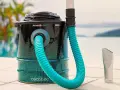 Aspirateur à cendres avec tuyau bleu et embout argenté, près d'une piscine.