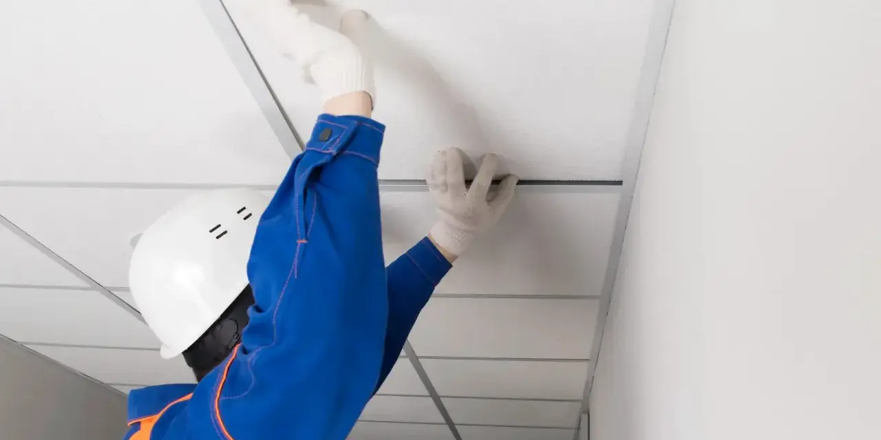 Pose d'un faux plafond dans un garage, améliorant l'isolation et l'esthétique.