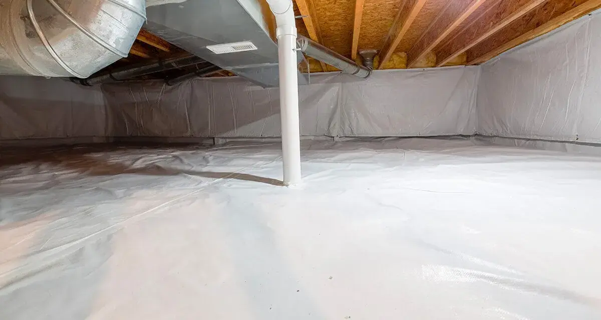 Vide sanitaire isolé avec une bâche blanche au sol et sur les murs, sous un plancher en bois avec des conduits.