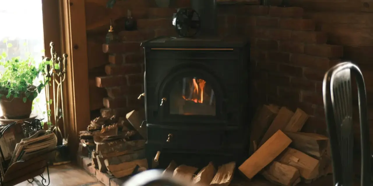 Poêle à bois avec arrivée d'air extérieur, crépitant joyeusement dans un coin cosy, entouré de bois prêt à chauffer.
