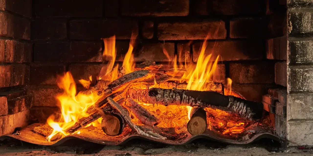 Un feu crépite dans une cheminée, réchauffant des morceaux de chêne bois de chauffage. Les flammes dansent joyeusement.