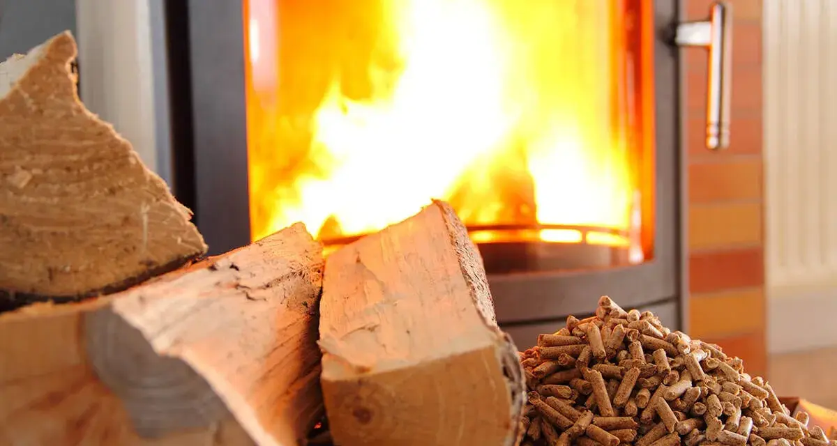 Bûches et granulés de bois près d'un poêle à granules en feu. Chaleur réconfortante pour l'hiver.