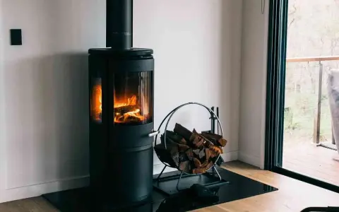 Poêle à bois moderne avec flammes vives et bûches. Une question se pose : peut-on installer un poêle à granule soi même ?