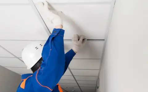 Pose d'un faux plafond dans un garage, améliorant l'isolation et l'esthétique.