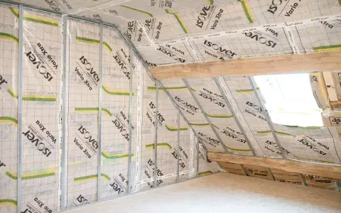 Pose d'un pare vapeur fibre de bois sur une structure métallique dans un grenier. Isolation en cours.