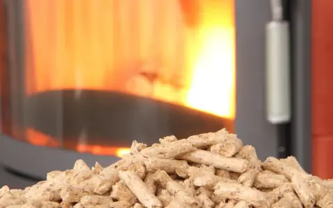 Un tas de granulés de bois attend patiemment devant un poêle à granule en feu. La chaleur réconfortante du feu promet une ambiance chaleureuse.