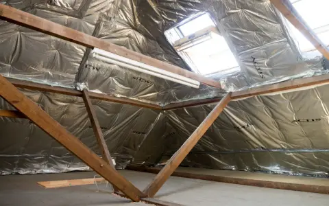 Isolation des combles : le prix au m2 dépend de la technique. Vue d'un grenier en cours d'isolation avec matériaux réfléchissants.