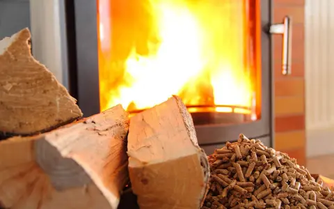 Bûches et granulés de bois près d'un poêle à granules en feu. Chaleur réconfortante pour l'hiver.
