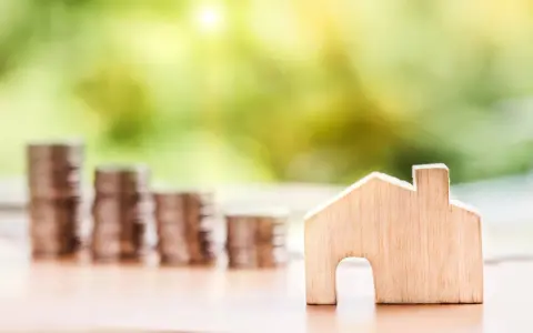 Une petite maison en bois et des piles de pièces de monnaie suggèrent un coup de pouce pour quel groupe : les investisseurs immobiliers.