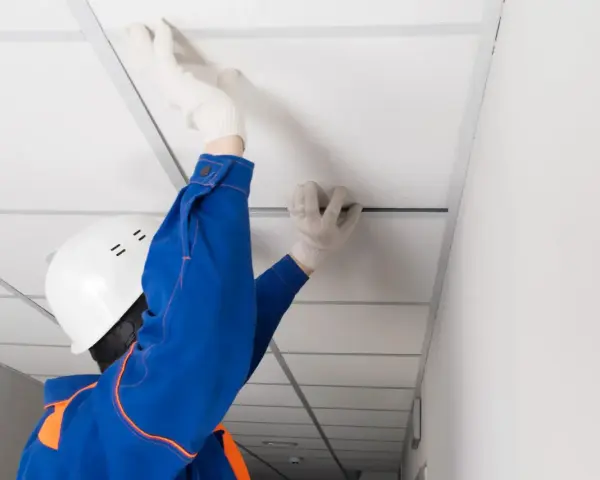 Pose d'un faux plafond dans un garage, améliorant l'isolation et l'esthétique.