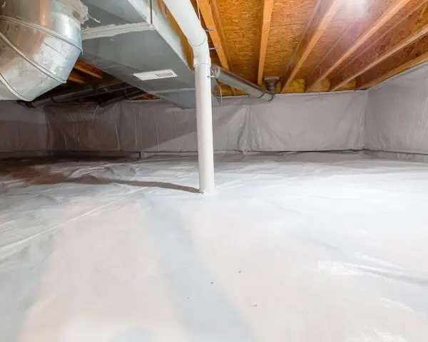 Vide sanitaire isolé avec une bâche blanche au sol et sur les murs, sous un plancher en bois avec des conduits.