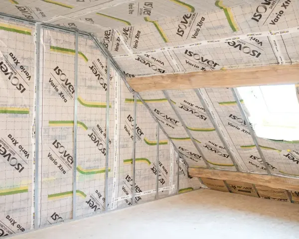 Pose d'un pare vapeur fibre de bois sur une structure métallique dans un grenier. Isolation en cours.