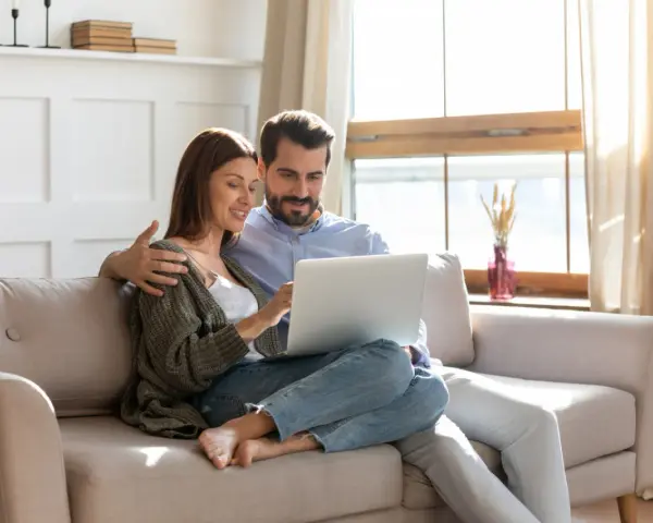 Couple planifiant l'amélioration de leur habitat, consultant un prêt sur leur ordinateur.