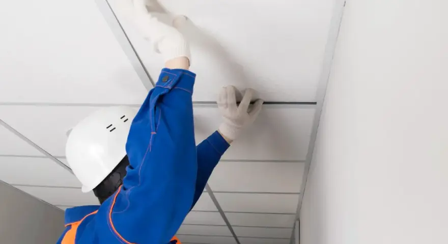 Pose d'un faux plafond dans un garage, améliorant l'isolation et l'esthétique.
