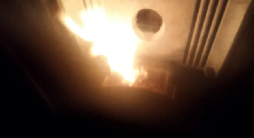 Flammes vives dans un poêle Piazzetta, peut-être un problème de tirage. La chaleur intense illumine l'intérieur.