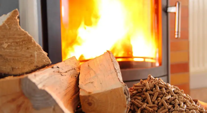 Bûches et granulés de bois près d'un poêle à granules en feu. Chaleur réconfortante pour l'hiver.