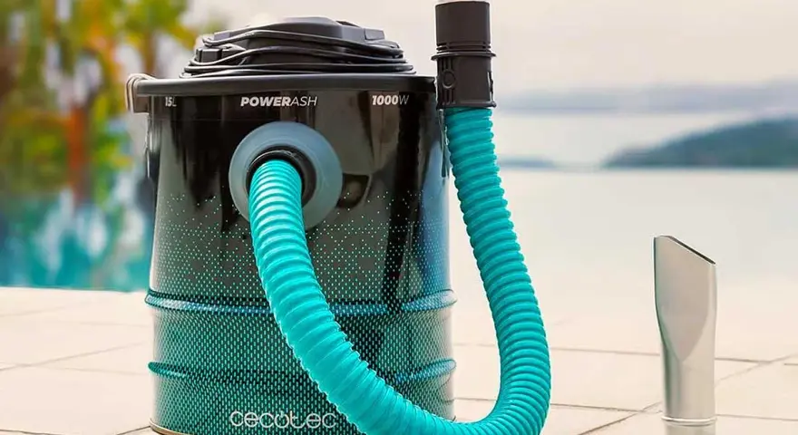 Aspirateur à cendres avec tuyau bleu et embout argenté, près d'une piscine.
