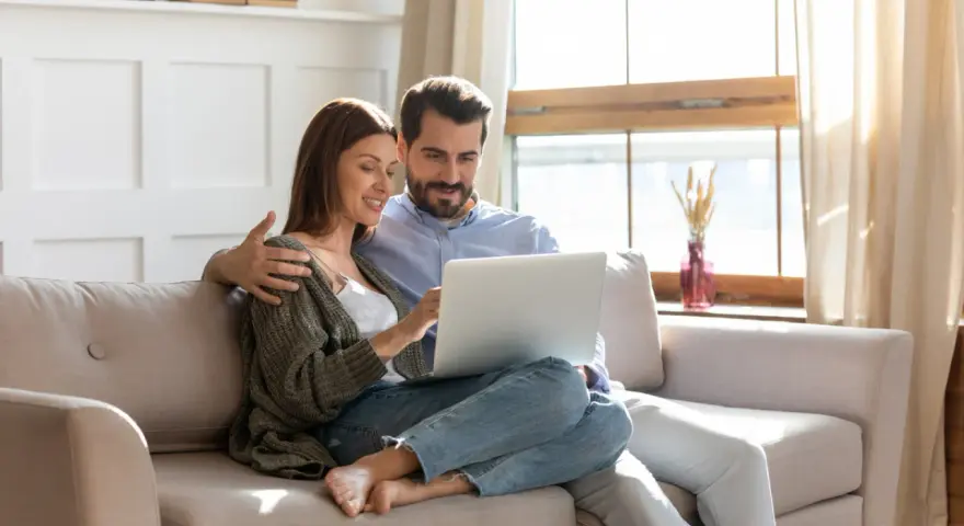 Couple planifiant l'amélioration de leur habitat, consultant un prêt sur leur ordinateur.