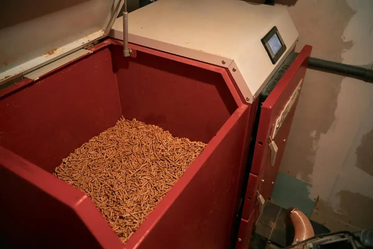 Ma prime rénov chaudière à granulés : le réservoir rouge est plein de granulés de bois, prêts à chauffer la maison.