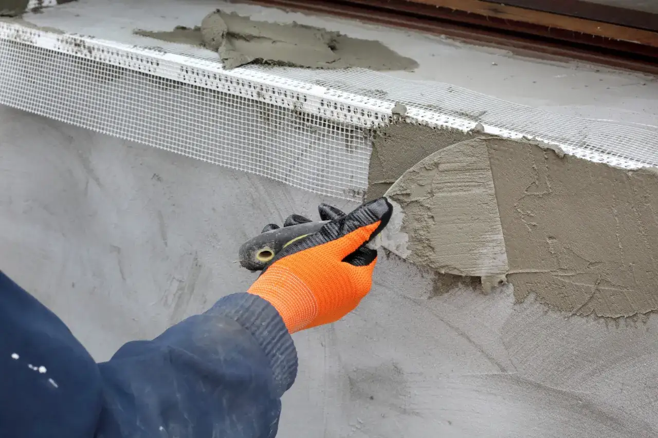 Application d'enduit sur une maille de renfort pour l'isolation extérieure d'une maison de 140m2. Le prix de cette isolation est un investissement pour le confort.