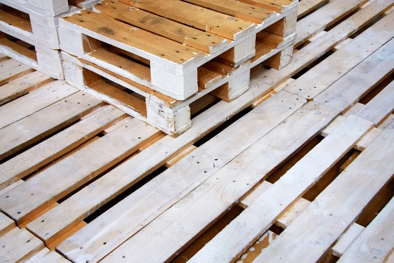 Des palettes en bois empilées. Peut-on brûler du bois de palette dans une cheminée ? La réponse est complexe et dépend du traitement du bois.