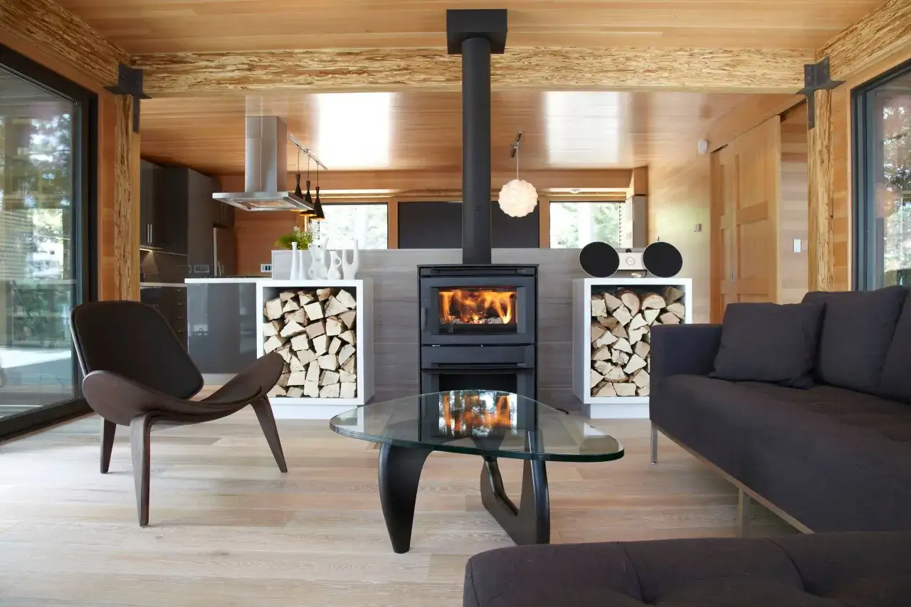 Salon moderne avec poêle à bois crépitant, canapé confortable et bois qui ne brûle pas empilé pour le chauffage.