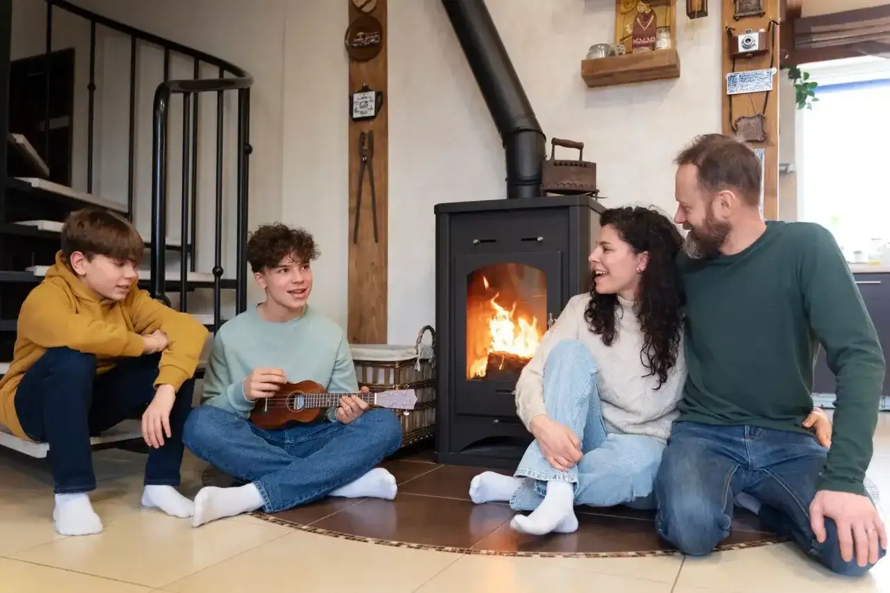 Famille r&eacute;unie autour d'un po&ecirc;le &agrave; granul&eacute;s, un fils joue du ukul&eacute;l&eacute;. Ambiance chaleureuse et conviviale.